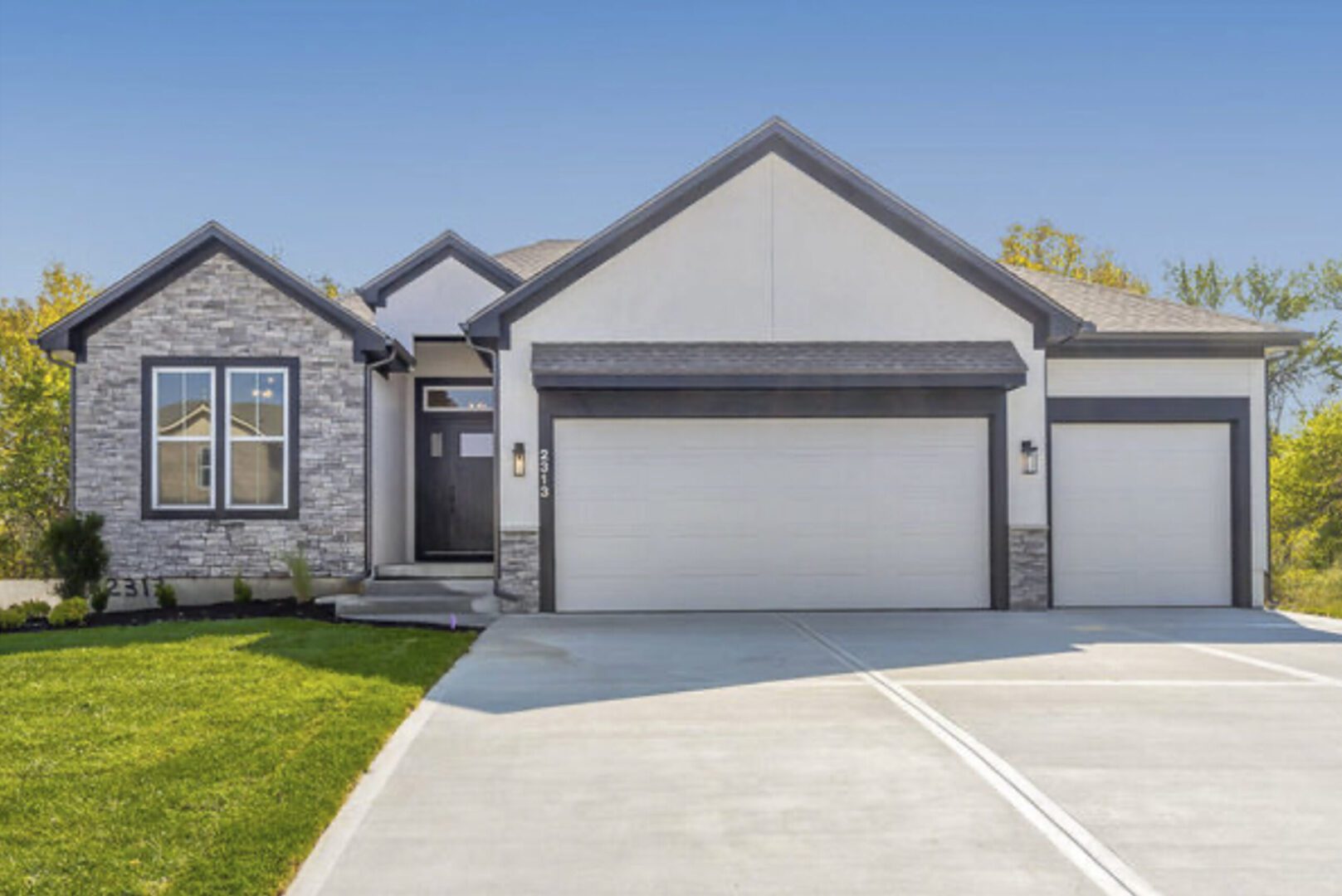 A home with two garages and a driveway.